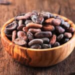 Unpeeled cocoa bean on wooden rustic background, close-up. Copy space