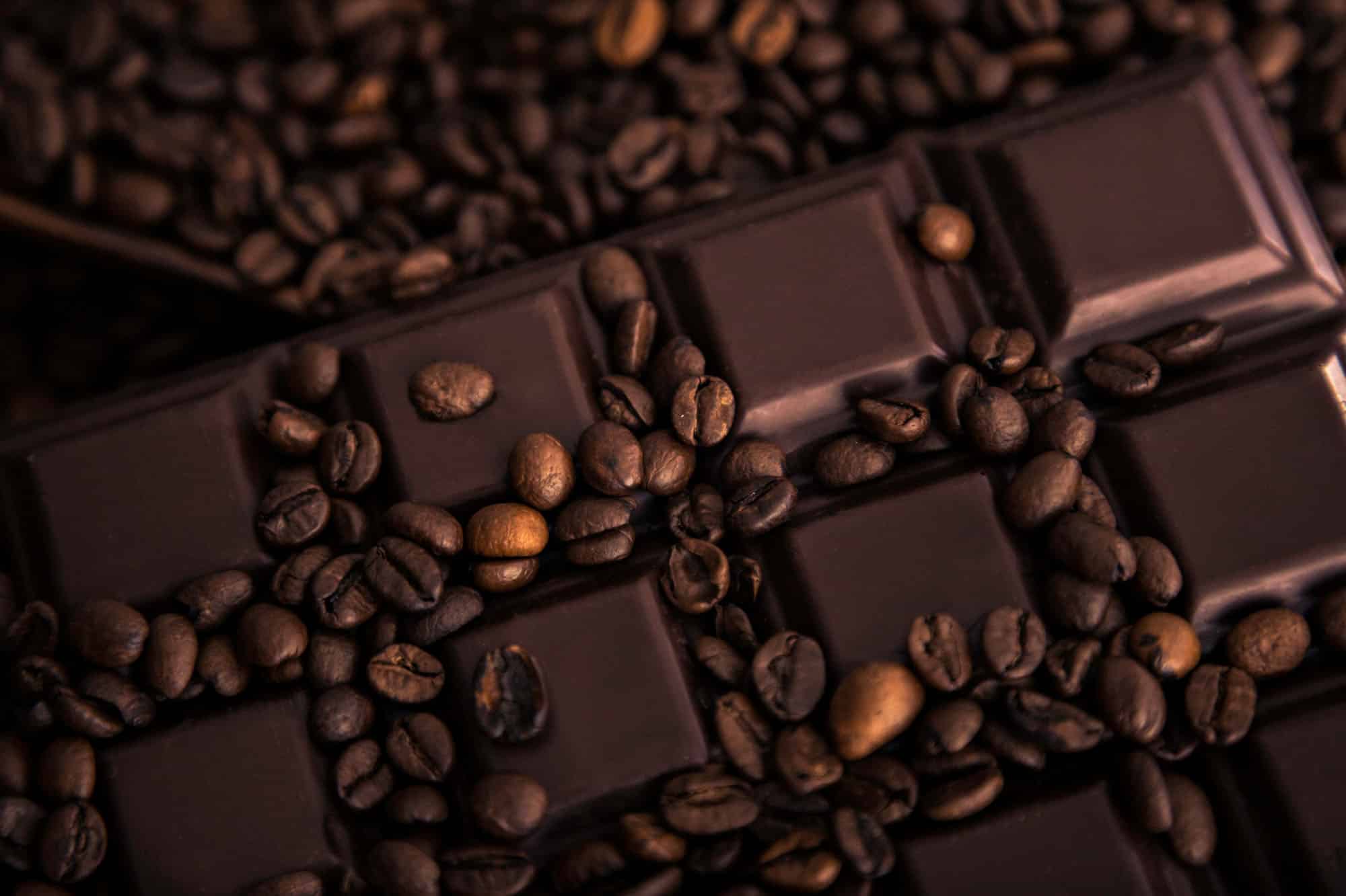 Roasted coffee beans and chocolate bar close-up.